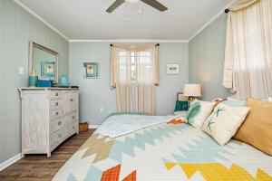 een slaapkamer met een bed, een dressoir en een raam bij 123 By the Sea in Oak Island