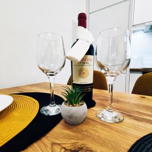 VIP Apartment في ياغودينا: زجاجة من النبيذ وكأسين من النبيذ على الطاولة