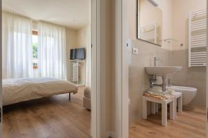a bathroom with a sink and a bed and a tub at Villa Rosa Antica in Lucca