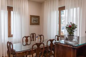 a dining room with a table and chairs and a window at Villa Rosa Antica in Lucca