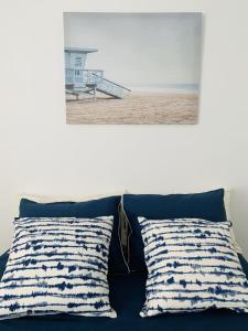a bed with two pillows and a picture of a beach at ESTUPENDO APARTAMENTO ENTERO in Marbella