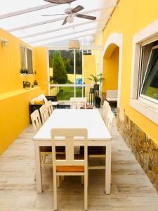 einen weißen Esstisch und Stühle auf einer Terrasse in der Unterkunft SUITE LIKE SWEET in Torres Vedras
