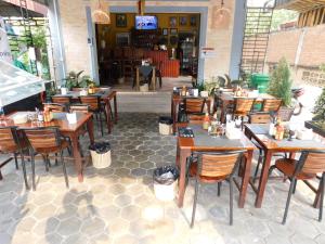a restaurant with wooden tables and chairs and a patio at Tom's Place in Siem Reap