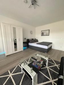 Sala de estar con cama y mesa en Idyllisches Apartment - Moderne 1ZKB Balkon 2 Personen Self-Check-in 24h, en Bad Nauheim