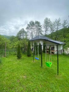 a yard with a swing in the grass at Golden Dream in Jajce