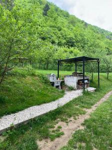 a picnic shelter with a bench in a field at Golden Dream in Jajce