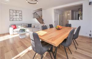 a dining room and living room with a wooden table and chairs at Cozy Home In Aigues-Mortes With Wifi in Aigues-Mortes