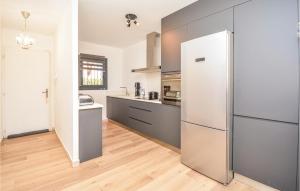 a kitchen with a refrigerator and a wooden floor at Cozy Home In Aigues-Mortes With Wifi in Aigues-Mortes