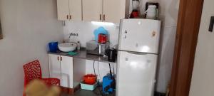 uma cozinha com um frigorífico branco e armários brancos em EnmicasaSSJ-Rosario em Rosário