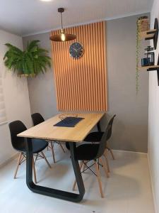 uma mesa de jantar com cadeiras e um relógio na parede em Casa moderna y acogedora. em Salento