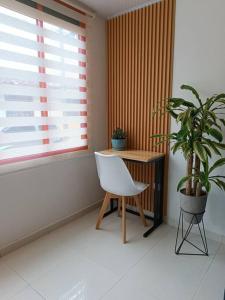 een kamer met een stoel, een tafel en een plant bij Casa moderna y acogedora. in Salento