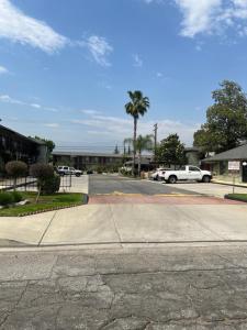 una calle con un coche blanco aparcado en un estacionamiento en Sunpark Inn & Suites, en San Bernardino