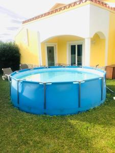 ein großer blauer Pool im Hof eines Hauses in der Unterkunft SUITE LIKE SWEET in Torres Vedras