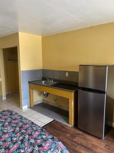 a kitchen with a stainless steel refrigerator and a sink at Sunpark Inn & Suites in San Bernardino