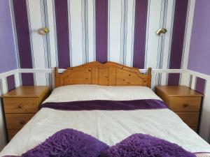 una camera da letto con pareti a righe viola e bianche e un letto di HemsbyholidaysRetroRetreat a Hemsby