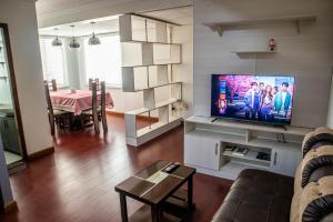 un salon avec une télévision et une salle à manger dans l'établissement Elegante y Funcional Apartamento en zona comercial de Sopocachi, à La Paz