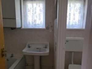 a bathroom with a sink and a toilet and a tub at HemsbyholidaysRetroRetreat in Hemsby