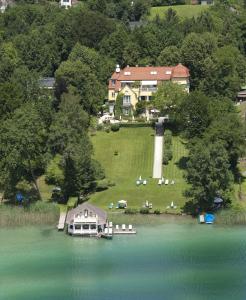 z góry widok na dom i jezioro w obiekcie Hotel Seeschlößl Velden w mieście Velden am Wörthersee