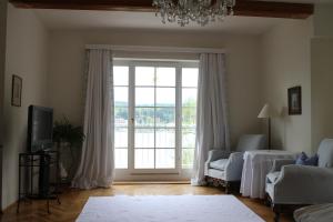 a living room with a large window and a chandelier at Hotel Seeschlößl Velden in Velden am Wörthersee