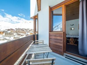 ławka na balkonie z widokiem na ośnieżone góry w obiekcie Appartement skis aux pieds à Tignes avec balcon, 6 couchages, proche commerces et navettes - FR-1-502-480 w mieście Tignes