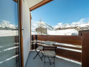 krzesło na balkonie z widokiem na pokryte śniegiem góry w obiekcie Appartement skis aux pieds à Tignes avec balcon, 6 couchages, proche commerces et navettes - FR-1-502-480 w mieście Tignes +6 zdjęć
