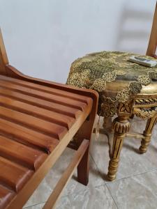 a wooden bench next to a table with a stool at Hello Pyramids inn in Cairo
