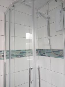 La salle de bains est pourvue d'une douche avec une porte en verre. dans l'établissement Two bedroom maisonette close toWarwick Uni, à Canley