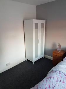 a bedroom with a bed and a dresser and a door at Two bedroom maisonette close toWarwick Uni in Canley