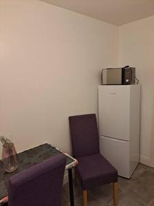 Cette chambre comprend une table, une chaise et un réfrigérateur. dans l'établissement Two bedroom maisonette close toWarwick Uni, à Canley