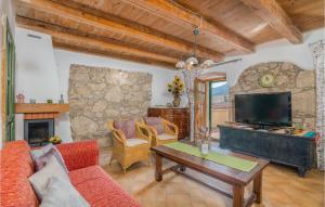 a living room with a couch and a table and a tv at Amazing Home In Draga Bascanska With Outdoor Swimming Pool in Draga Bašćanska