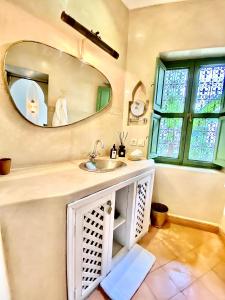 un bagno con lavandino e specchio di Riad Dar Adal exclusivité 2 à 6 personnes petit déjeuner compris place jemaa El fna a Marrakech