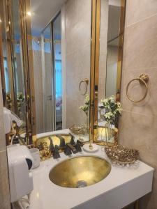 a bathroom with a gold sink and a mirror at Espana Condo Resort Pattaya BY MAM in Jomtien Beach