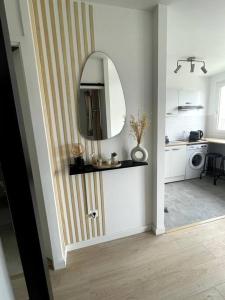 pasillo con espejo en la pared y cocina en appartement cosy et lumineux, en Orly