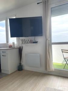 a living room with a large window and a flat screen tv at appartement cosy et lumineux in Orly