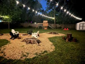 einen Hinterhof mit einer Feuerstelle und einem Spielplatz mit Lichtern in der Unterkunft Cozy Family-Friendly home w/ fenced-in backyard in Marietta