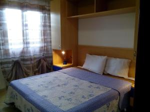 een kleine slaapkamer met een bed en een raam bij Villa Giulia in Vieste