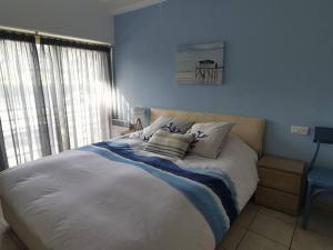 a blue bedroom with a bed with pillows on it at L'apartment paradise sur mer/80sqm beach front +AC in Menton