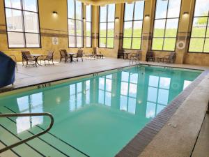 una grande piscina con sedie e tavoli in un edificio di Holiday Inn Express Casper I-25, an IHG Hotel a Casper