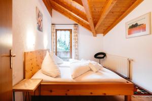 a bedroom with a bed with white sheets and a window at Appart Taverne in Mayrhofen