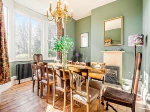 a dining room with a table and chairs and a fireplace at Barleycombe in Loxton