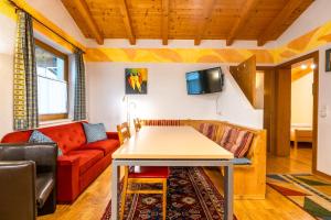 sala de estar con mesa y sofá en Appart Taverne, en Mayrhofen