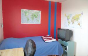 a room with a bed and a tv and red wall at Stunning Home In Helsingborg With 4 Bedrooms And Wifi in Helsingborg