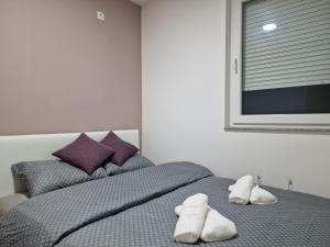 ein Schlafzimmer mit einem Bett mit zwei weißen Handtüchern darauf in der Unterkunft Apartman - MOST 2 in Ruma