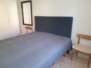 1 dormitorio con 1 cama azul y 2 sillas en Välrenoverad fin lägenhet i charmigt område, en Söderhamn