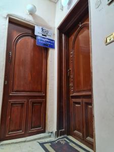 two wooden doors in a building with a sign on it at Hello Pyramids inn in Cairo