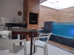 een keuken met een tafel en stoelen en een zwembad bij Casa com piscina a 500m da praia in Salinópolis