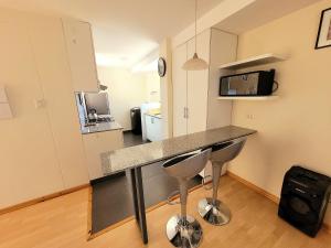 a kitchen with a counter and two bar stools at Fiflos Apartament in Cusco