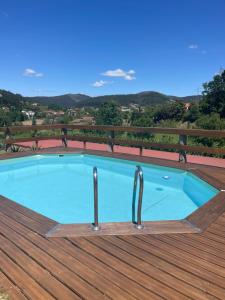 a swimming pool on top of a wooden deck at Loft - Casinha à Porta in Arouca