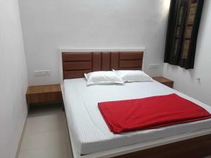 Un dormitorio con una cama con una manta roja. en OYO HOME RKR.inn, en Dabok