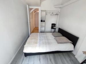 a bedroom with a bed in a white room at Centre Historique - Charmant T3 - 1h de l Océan in Orthez